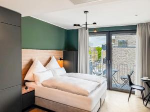 a bedroom with a bed and a balcony at Townhome Hotel Hannover - Digital Access - kontaktloser Check-in in Hannover