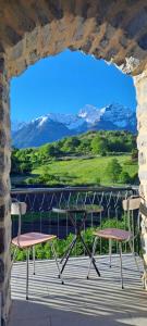 a table and two chairs on a balcony with mountains at Aosta Stunning Panoramic Views From Modern Two Bedroom Apartment in Aosta