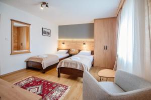 Habitación de hotel con 2 camas y sofá en Hotel Zlatni bor, en Žabljak