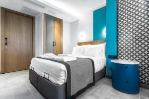 - une chambre avec un grand lit et un mur bleu dans l'établissement PAMPHYLIA HOTEL, à Valence