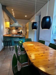 カールスルーエにあるMaisonettewohnung im Loft Stil mit wunderschöner Terrasseのキッチン(木製テーブル、緑の椅子付)