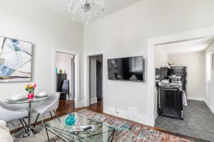 a white living room with a table and a tv at Apartment in the James South Neighborhood in Hamilton