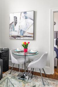 a dining room with a glass table and chairs at Apartment in the James South Neighborhood in Hamilton