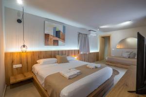 een slaapkamer met een groot bed en 2 handdoeken bij Arameras Beach Resort in Ksamil