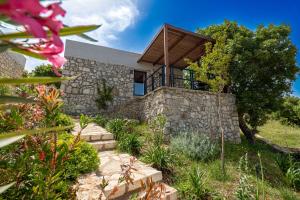 een stenen huis met een houten dak bij Arameras Beach Resort in Ksamil