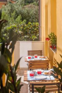 - deux tables avec des assiettes de nourriture sur la terrasse dans l'établissement 0.8 Guest House, à Porto Ercole