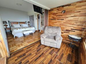 een slaapkamer met een bed, een stoel en een bank bij Departamento Frente al Mar in Viña del Mar