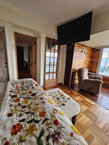 een slaapkamer met een bed met een bloemendeken erop bij Departamento Frente al Mar in Viña del Mar