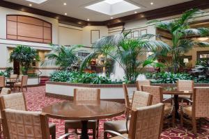 een lobby met tafels, stoelen en planten bij Chicago Marriott Northwest in Hoffman Estates