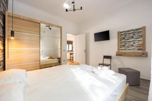 a bedroom with a large white bed and a television at MonteCasa in Epanomi