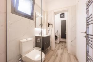 a white bathroom with a toilet and a sink at MonteCasa in Epanomi