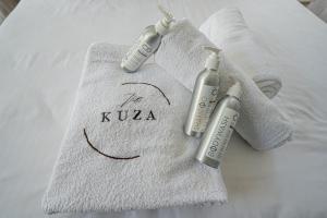 キリフィにあるKuza The Palm Villas at Vipingoのベッドの上に無料のタオル2枚(注射ボトル2本付)