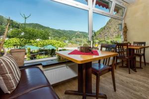 une table et des chaises dans une chambre avec une grande fenêtre dans l'établissement Stumbergers Hotel, à Cochem