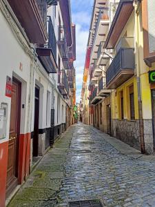 una strada di ciottoli in un vicolo tra gli edifici di La Casita de Diana Laredo, Casco Antiguo a Laredo