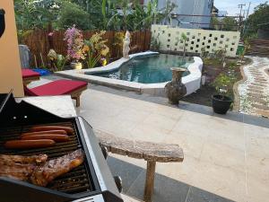 a backyard with a grill and a swimming pool at Villa NiMo Jimbaran in Jimbaran