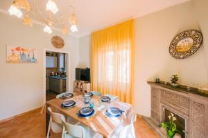 een eetkamer met een tafel en een open haard bij Berardino Holiday House in Ravello