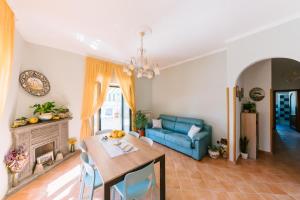 een woonkamer met een tafel en een blauwe bank bij Berardino Holiday House in Ravello