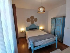 una camera con letto blu e armadio blu di Casa Pereira a Vila Nova de Milfontes