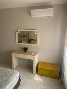 um quarto com uma cama e uma mesa com um espelho em Frente á Praia em Portimão