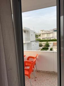 une paire de chaises orange assises sur un balcon dans l'établissement Guesthouse Butrinti, à Ksamil