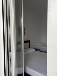 - une chambre avec 2 lits et une porte en verre dans l'établissement Guesthouse Butrinti, à Ksamil