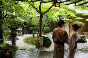 奈良Ryokan Asukasou at the entrancne of Nara park的站在花园中的男女