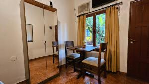 d'une salle à manger avec une table, des chaises et une fenêtre. dans l'établissement Iguazu Hojas Verdes, à Puerto Iguazú