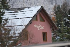 ein rosafarbenes Gebäude mit den Worten Alaskan Hütte drauf in der Unterkunft Hotel Clari in Claviere