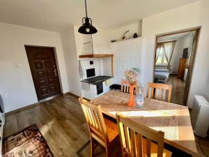 uma cozinha e sala de jantar com uma mesa e uma lareira em Biebrzańskie Zacisze em Goniadz