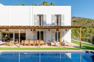 eine Villa mit einem Pool und einem Haus in der Unterkunft Cap Martinet Talamanca Vila Can Tashellu, Boutique 5 bed - Sea and Forest View in Talamanca