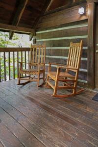 due sedie a dondolo sedute su un portico di una cabina di Cozy Cabin! Hot Tub, King Bed, Fireplace, & Pool a Gatlinburg