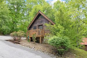 una baita di tronchi con portico e terrazza. di Cozy Cabin! Hot Tub, King Bed, Fireplace, & Pool a Gatlinburg