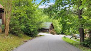 una strada che conduce a un fienile e a una casa di Cozy Cabin! Hot Tub, King Bed, Fireplace, & Pool a Gatlinburg