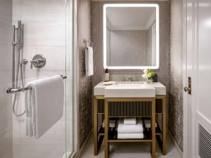 bagno con lavandino, specchio e doccia di Fairmont Hotel Macdonald a Edmonton