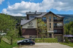 a building with a car parked in front of it at MK Resort (ex. Magiya Karpat) in Bukovel