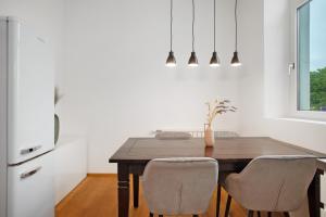 - une salle à manger avec une table et des chaises en bois dans l'établissement Zeitlos Zuhause Bregenz, à Bregenz