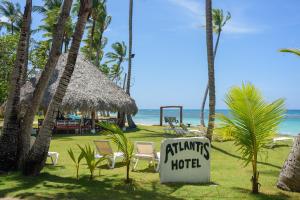 een hotelbord voor een strand met palmbomen bij Hotel Atlantis in Las Terrenas