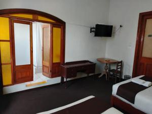 Habitación con cama, mesa y ventana en La mansión del Monarca, en Arequipa