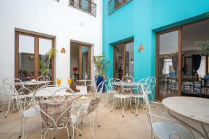 a patio with tables and chairs and a blue wall at Alvor Ar de Mar in Alvor