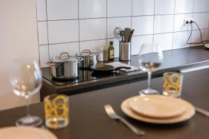 a kitchen counter with two wine glasses and a stove at Chic Cityscape Apartment Ghent in Ghent