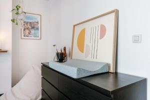 a wooden dresser with a picture on top of it at Chic Cityscape Apartment Ghent in Ghent