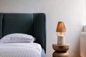 a bedroom with a bed and a lamp on a table at Chic Cityscape Apartment Ghent in Ghent