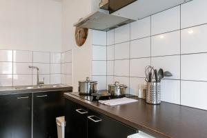 a kitchen with pots and pans on a counter at Chic Cityscape Apartment Ghent in Ghent