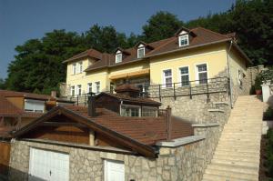 una grande casa gialla con tetto marrone di Alabárdos Panzió és Apartmanház a Esztergom