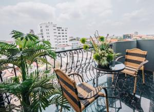 Un balcón con sillas y una mesa con plantas. en V Hotel Vientiane en Vientián