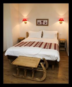 - une chambre avec un grand lit et une table en bois dans l'établissement The Originals Boutique, Hôtel La Ferme du Pape, Eguisheim, à Eguisheim