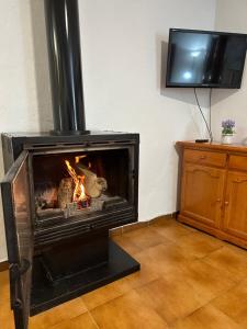 a fireplace in a living room with a fire in it at Las Vistas in Bubión