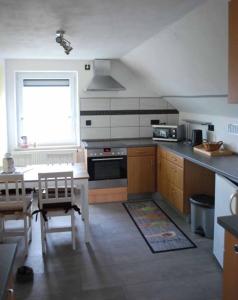 a kitchen with a table and a stove and a window at Ferienwohnung Hammerwaldblick in Selb