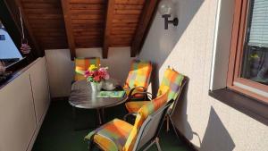 a table and chairs on a balcony with a table and flowers at Ferienwohnung Hammerwaldblick in Selb