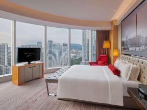 ein Hotelzimmer mit einem großen Bett und einem TV in der Unterkunft Sofitel Guangzhou Sunrich in Guangzhou